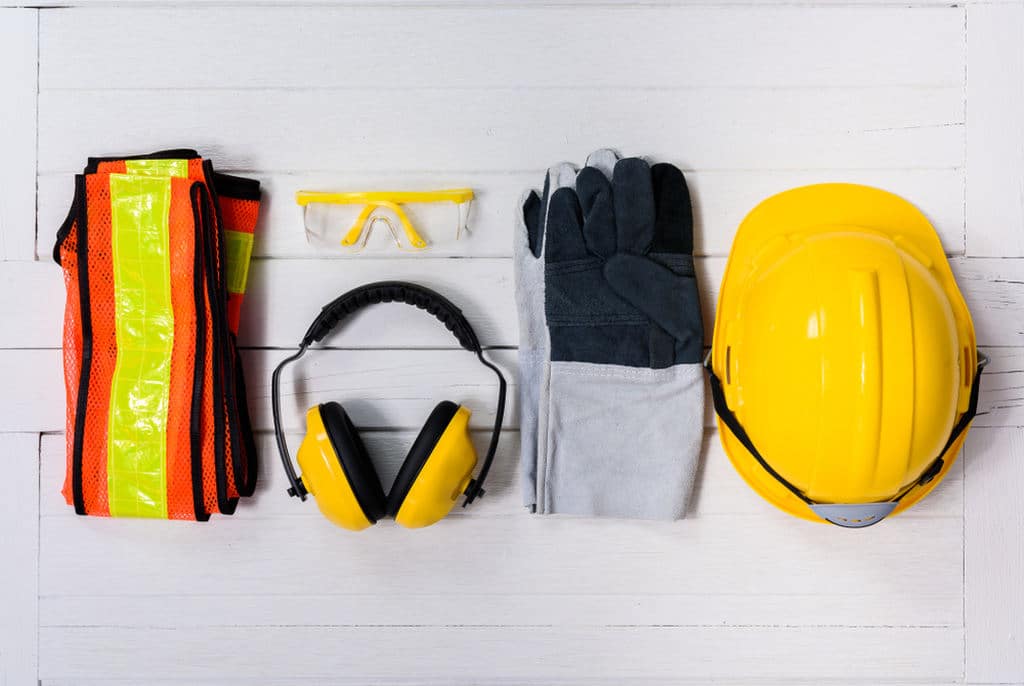Principais tipos de EPI, como capacete, protetor auricular, colete, óculos de proteção e luvas